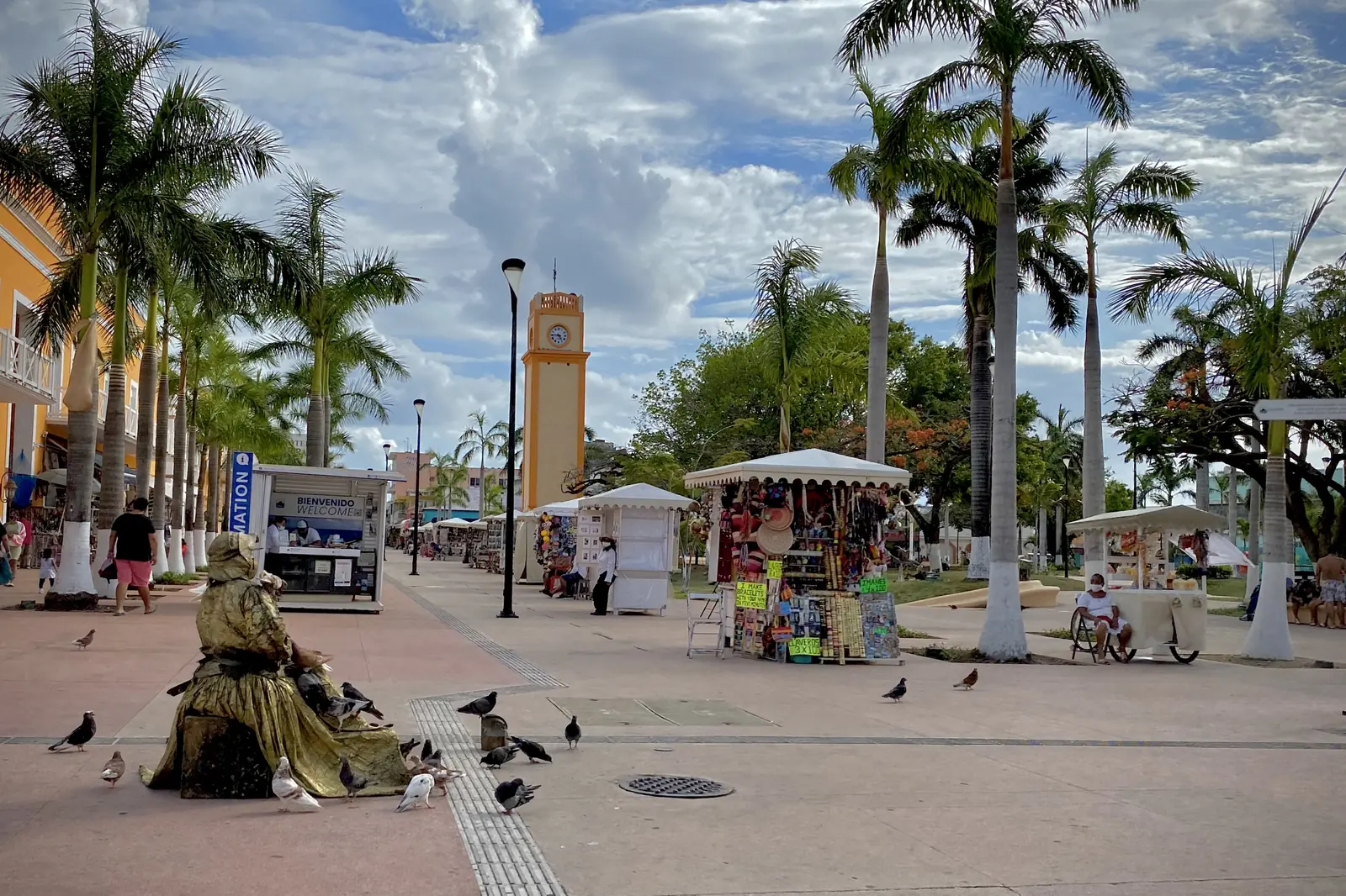 Palmy, hodinová věž a tržní stánky podél dlážděného náměstí v San Miguel de Cozumel